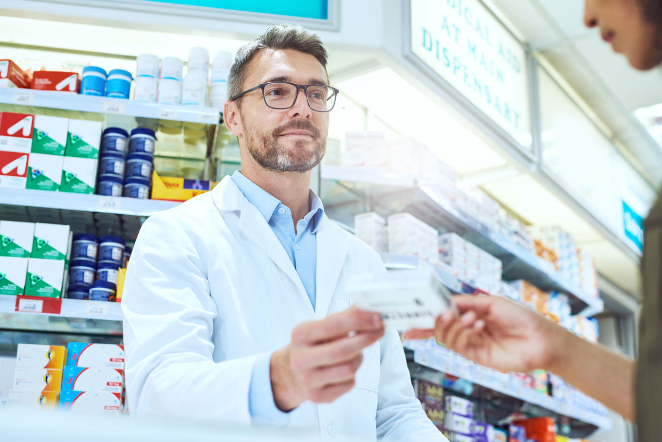 Farmaceuta wydaje leki na trzustkę pacjentowi