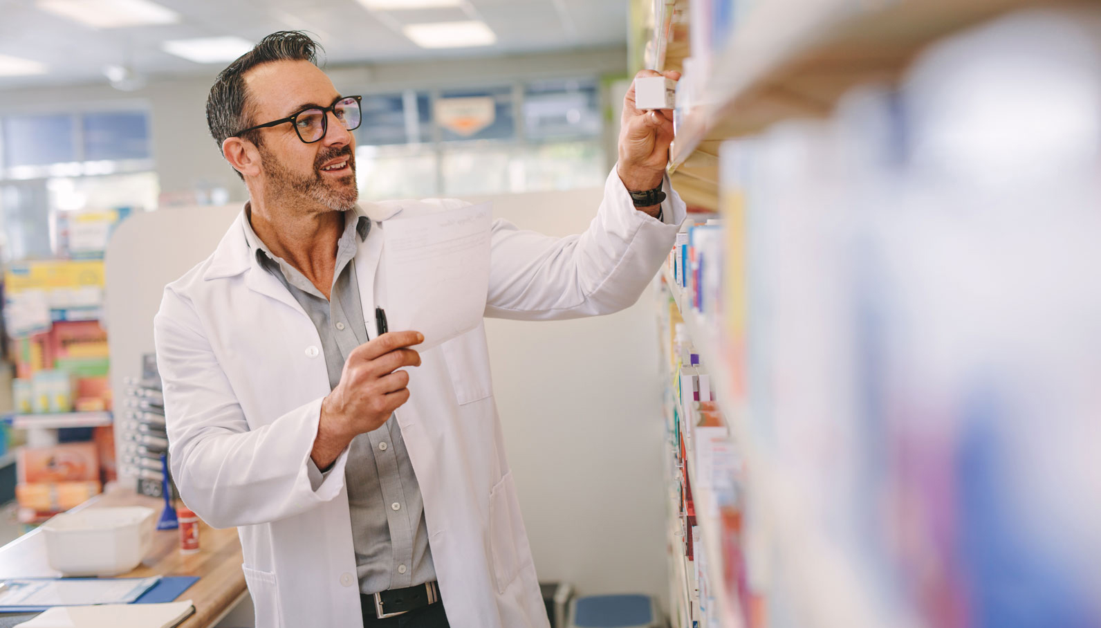 farmaceuta ustawia leki na polce