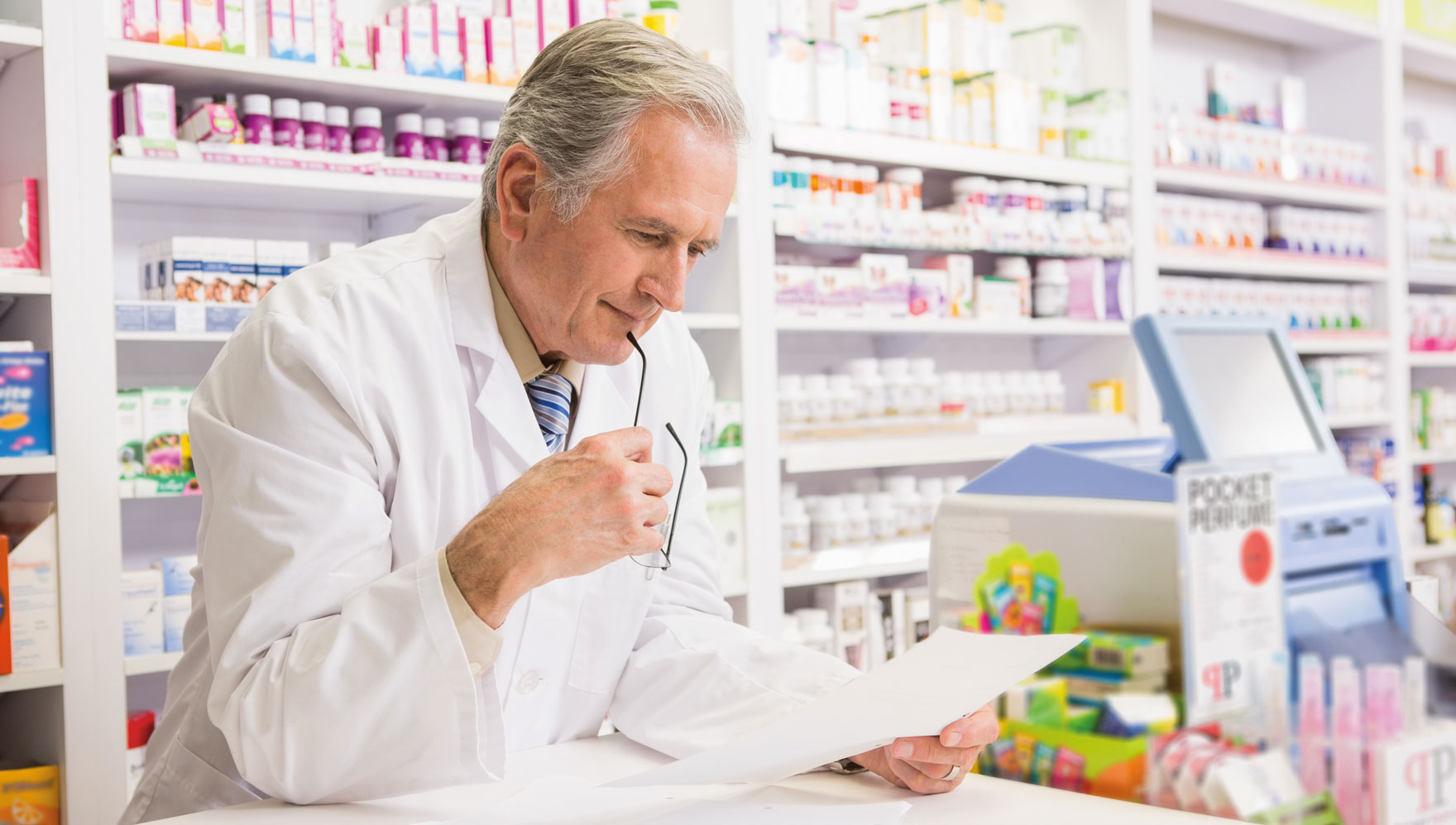 farmaceuta czyta cos kartki w aptece