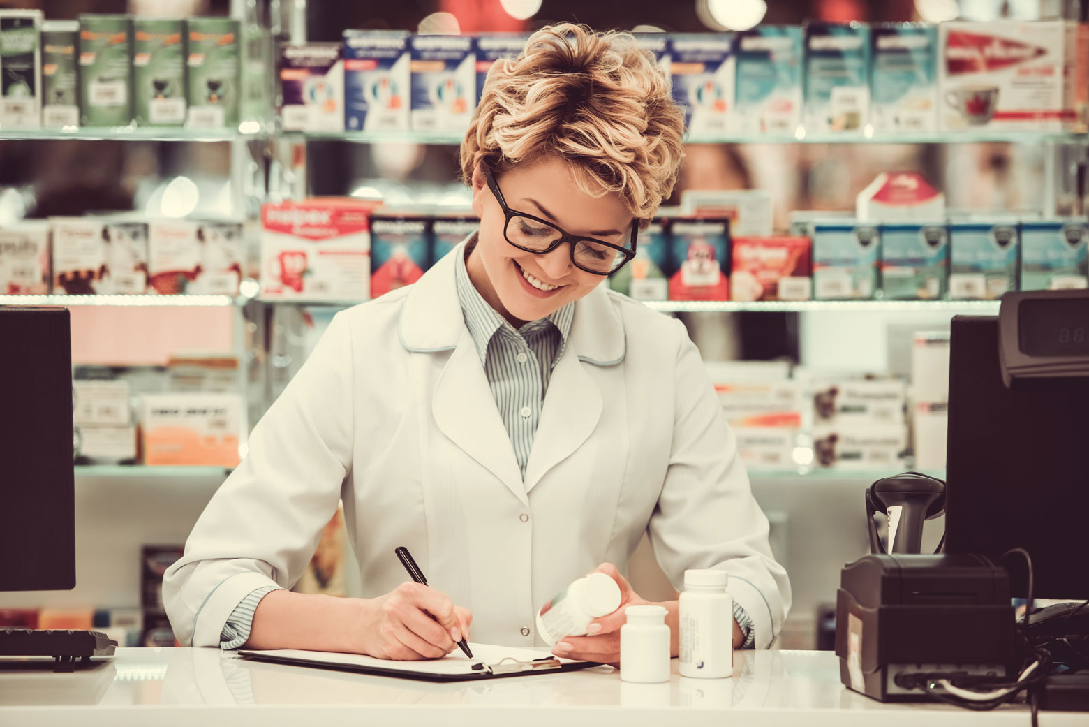 farmaceutka wypelnia recepte i trzyma lekw dloni