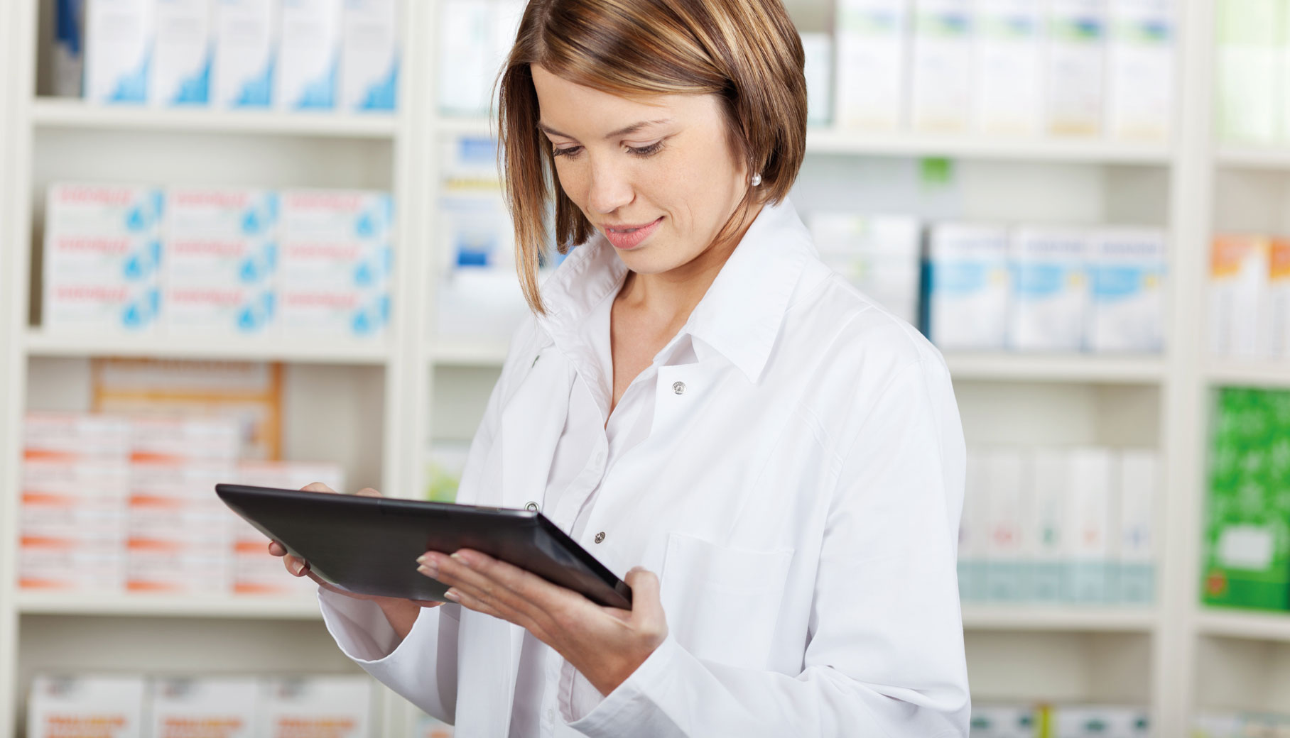 farmaceutka w aptece czyta z tabletu